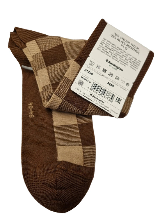 A pair of brown and beige checkered wool socks with a white product tag attached, displayed on a white sheet of paper.