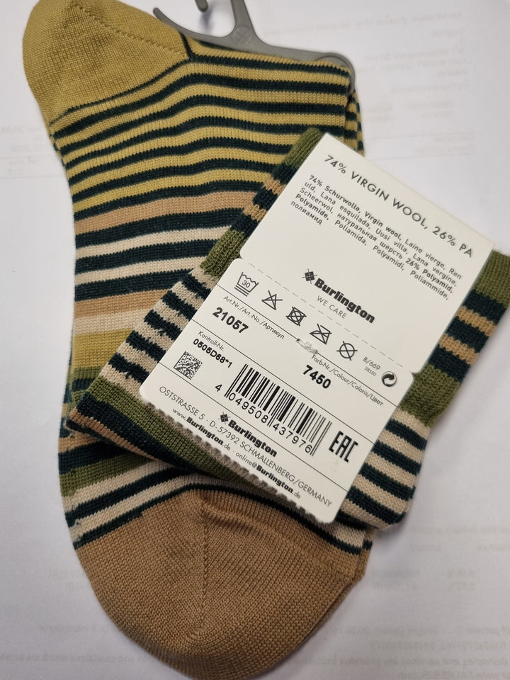 A pair of knit socks with vertical stripes in olive green, dark navy, and beige, featuring a solid tan heel and toe. A white paper product tag is attached to one sock, and a gray plastic hanger hook is visible on the other, all laid out on a white surface.